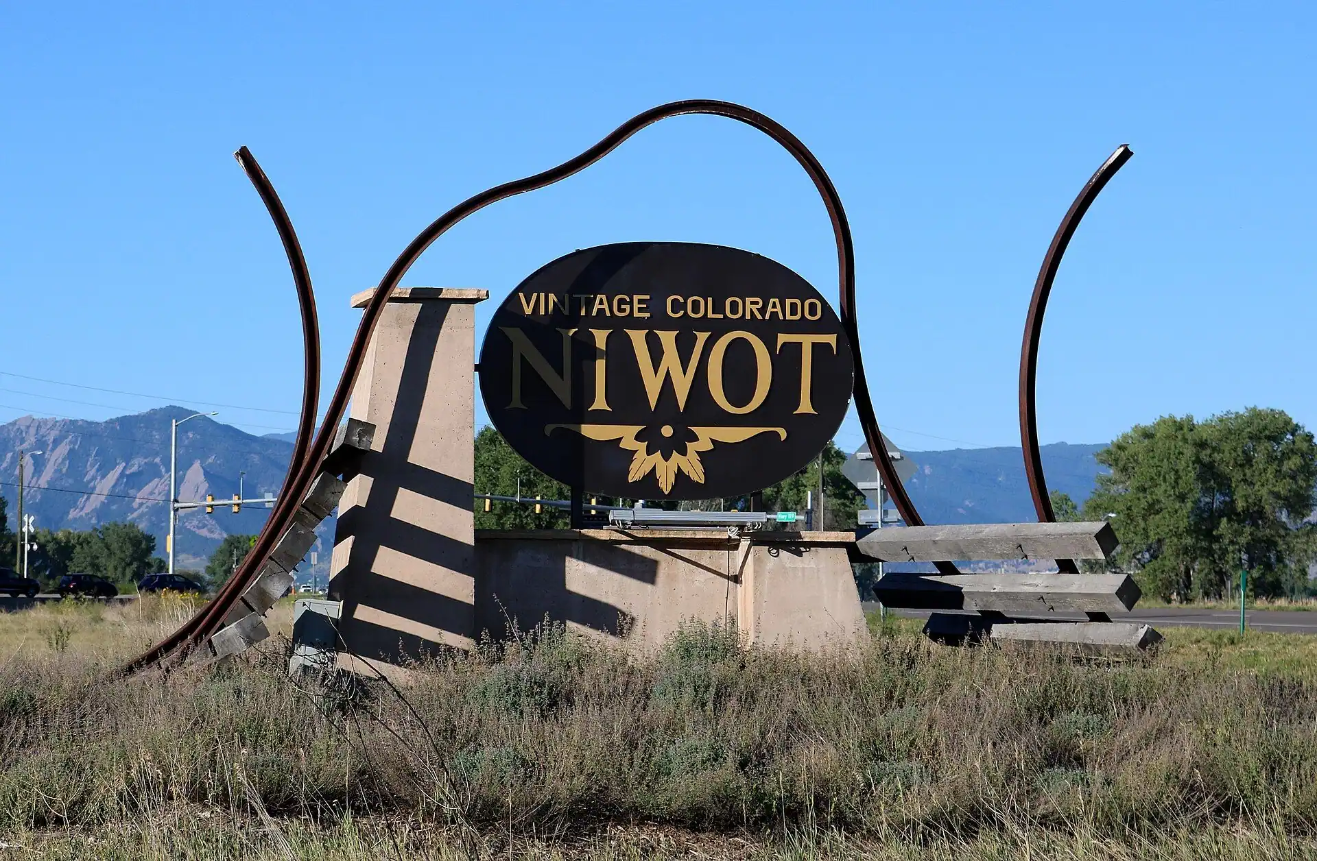 The Niwot, Colorado town sign on the Diagonal Highway with the Flatirons behind